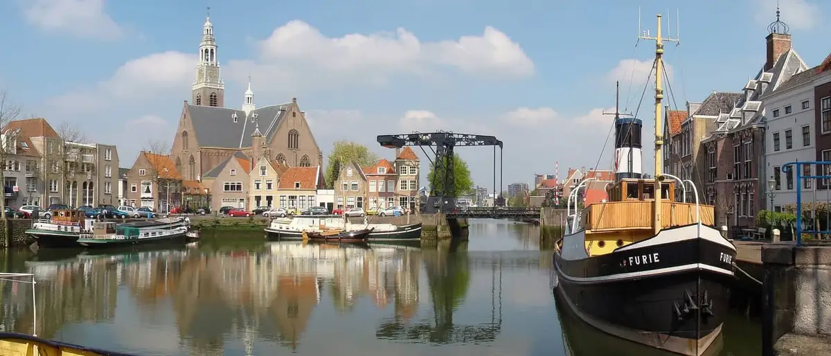 De haven van Maassluis met de Grote Kerk en een stoomsleper